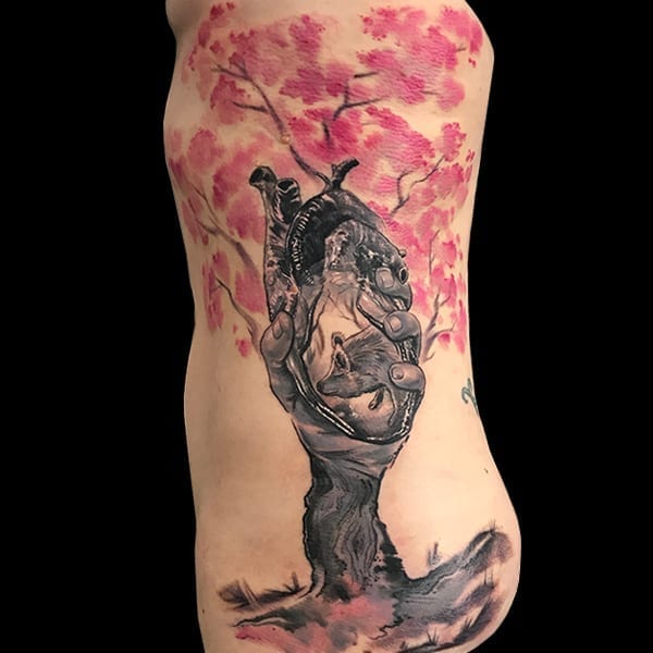 realistic hand and cherry blossom tattoo
